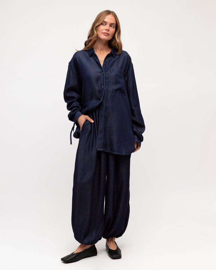 Woman wearing a label of love denim outfit on a white background