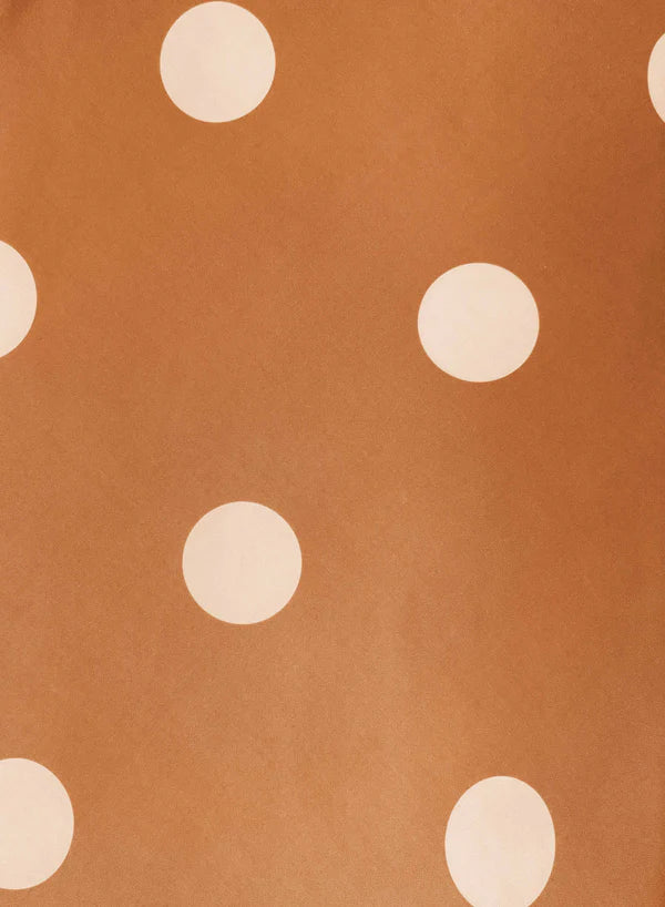 Pattern of beige polka dots on a brown background