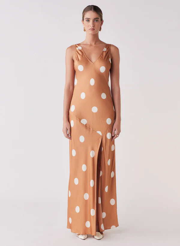 Woman wearing a polka dot dress with a plain background