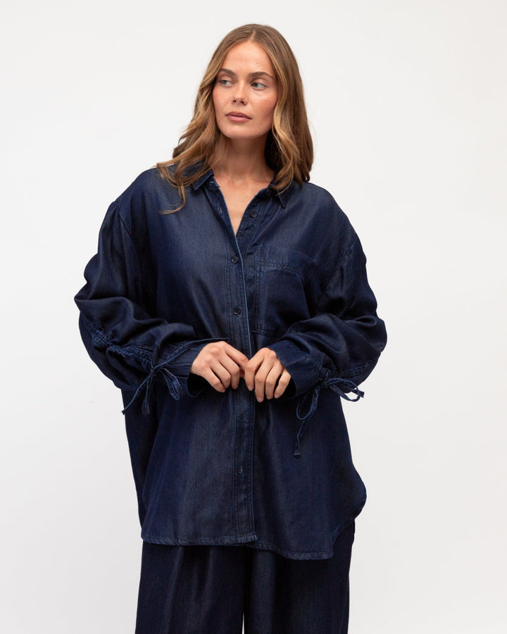 Woman wearing a label of love navy blue shirt and pants on a white background