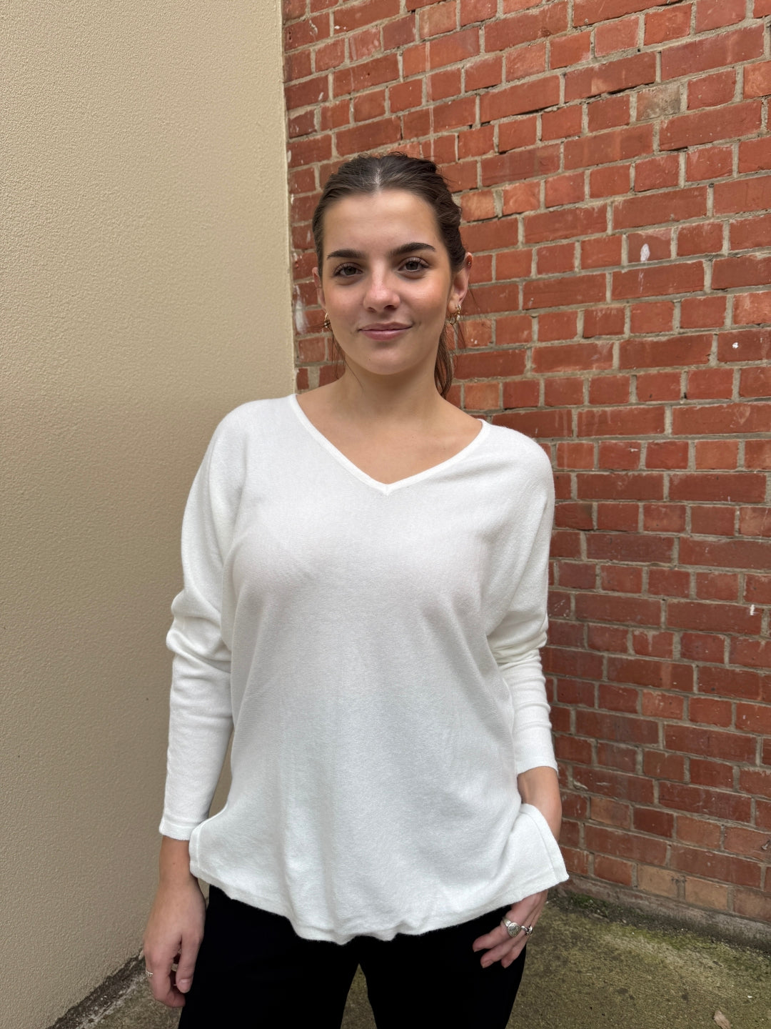 Stella wearing a white sunny girl V neck sweater .