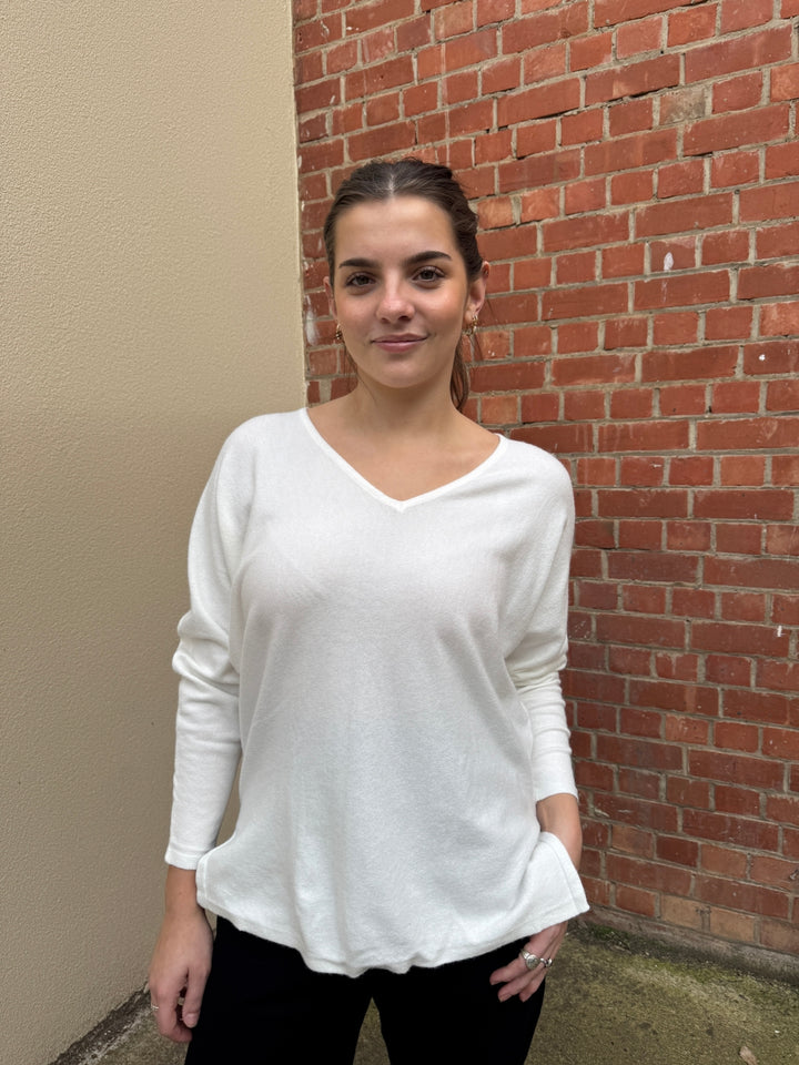 Stella wearing a white sunny girl V neck sweater .